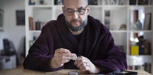 Middle aged man with type 2 diabetes using blood sugar measurement device to monitor type 2 diabetes, which is often treated with SGLT2 inhibitors