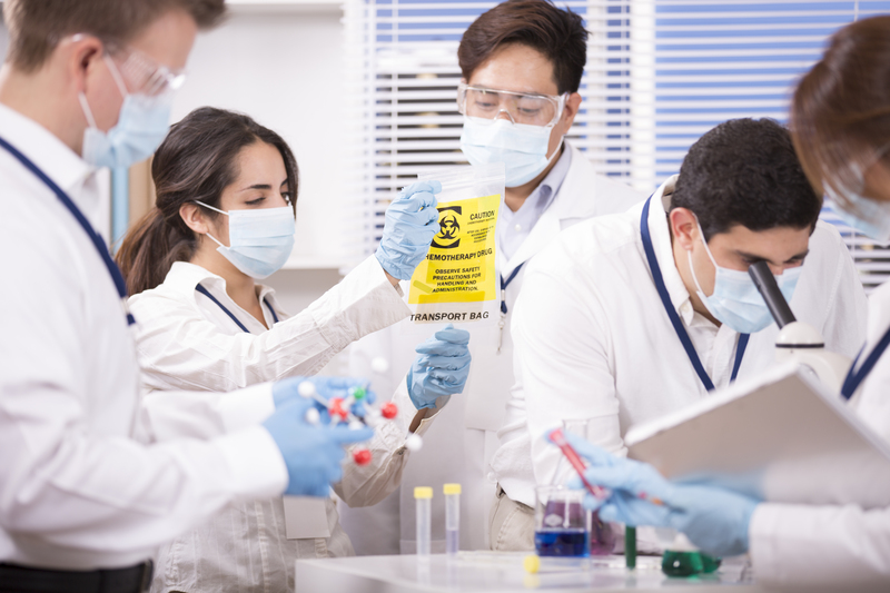 Multi-ethnic group of scientists in science laboratory. Cancer research.