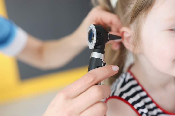 Doctor examines ear drum of little girl
